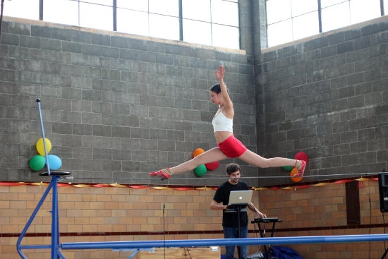 A beam walker jumps improbably high above the beam.