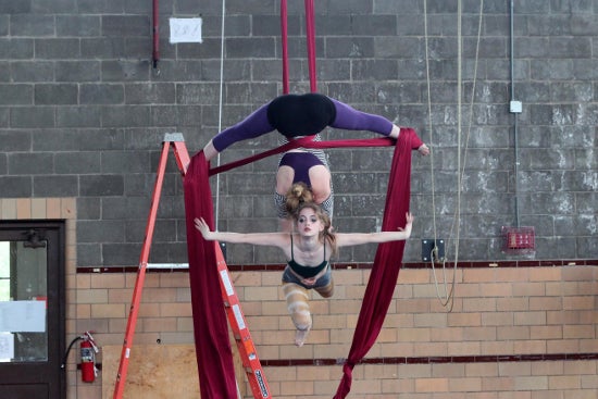 Two aerial performers in a graceful pose.