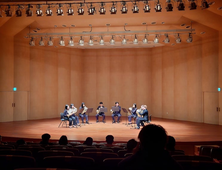 A French horn ensemble performing in the main concert hall at Hanyang University.