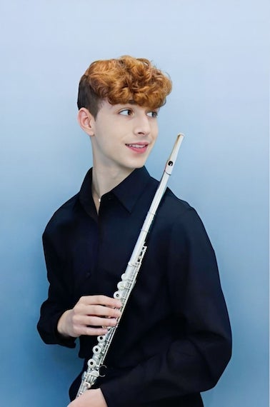A headshot of me and my flute in front of a pale gradient blue backdrop.