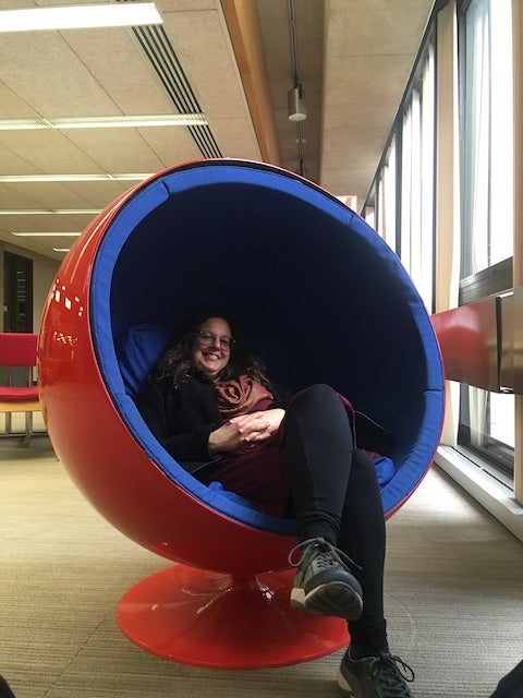 My mom in a bowl-shaped womb chair in the library