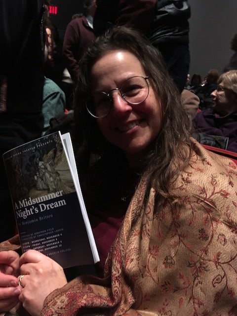 My mom holding up the opera program in the theater