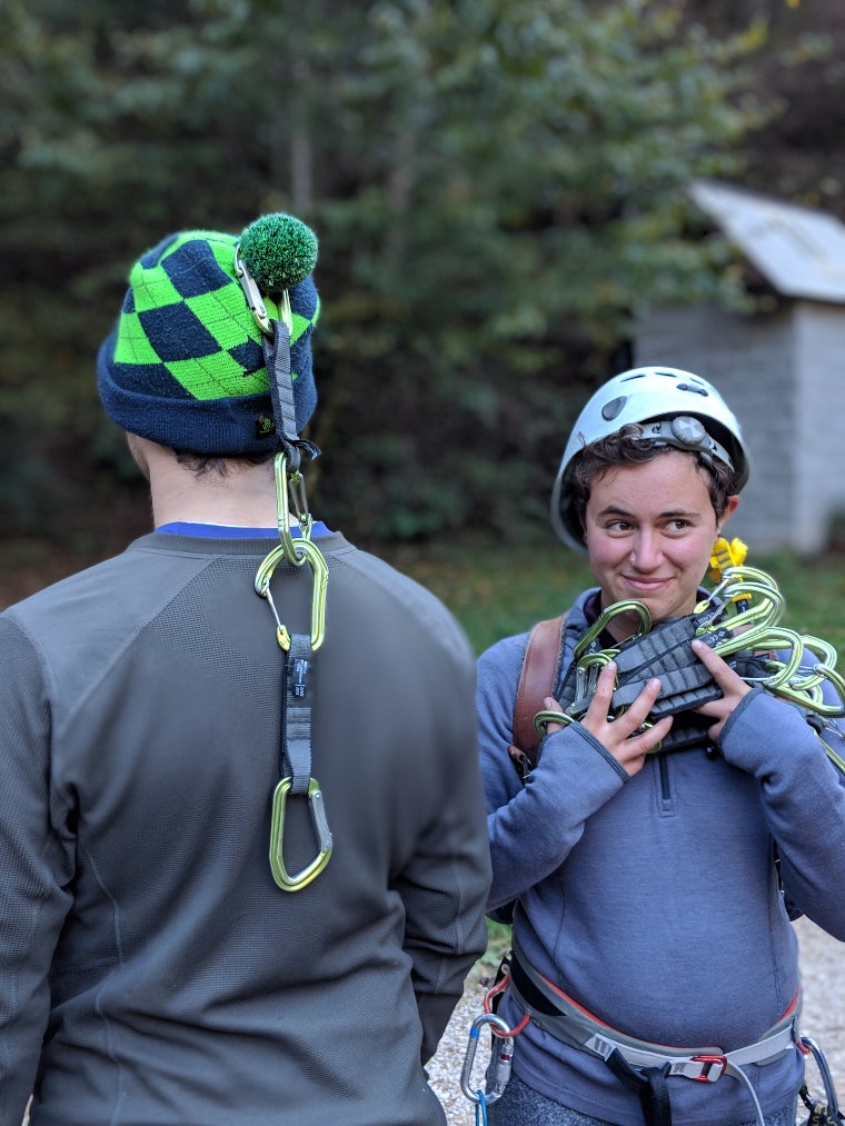 Piper and Paul holding up some carabiners and smiling