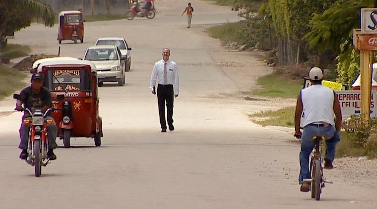 Man walking down a village street.