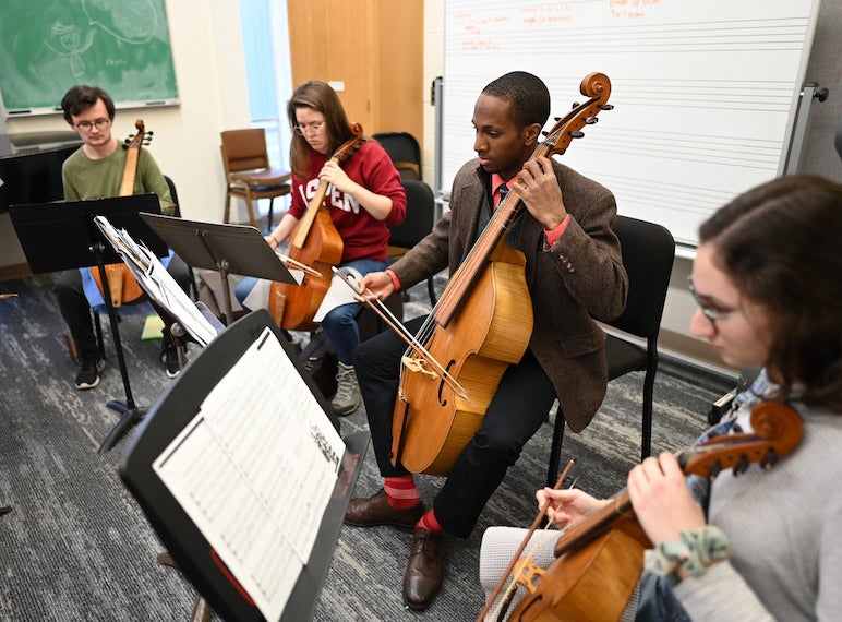 Students play the viola in a small studio.
