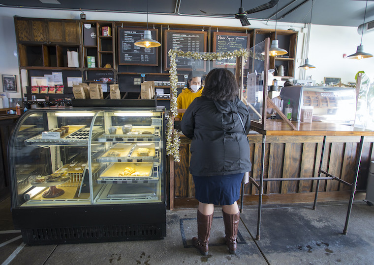 A woman stands in line at a coffee house.