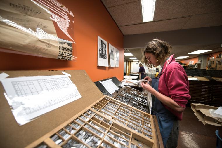 Student examining type in the letterpress studio