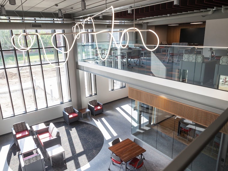 Open atrium with large windows, modern seating areas, and a sculptural light fixture.