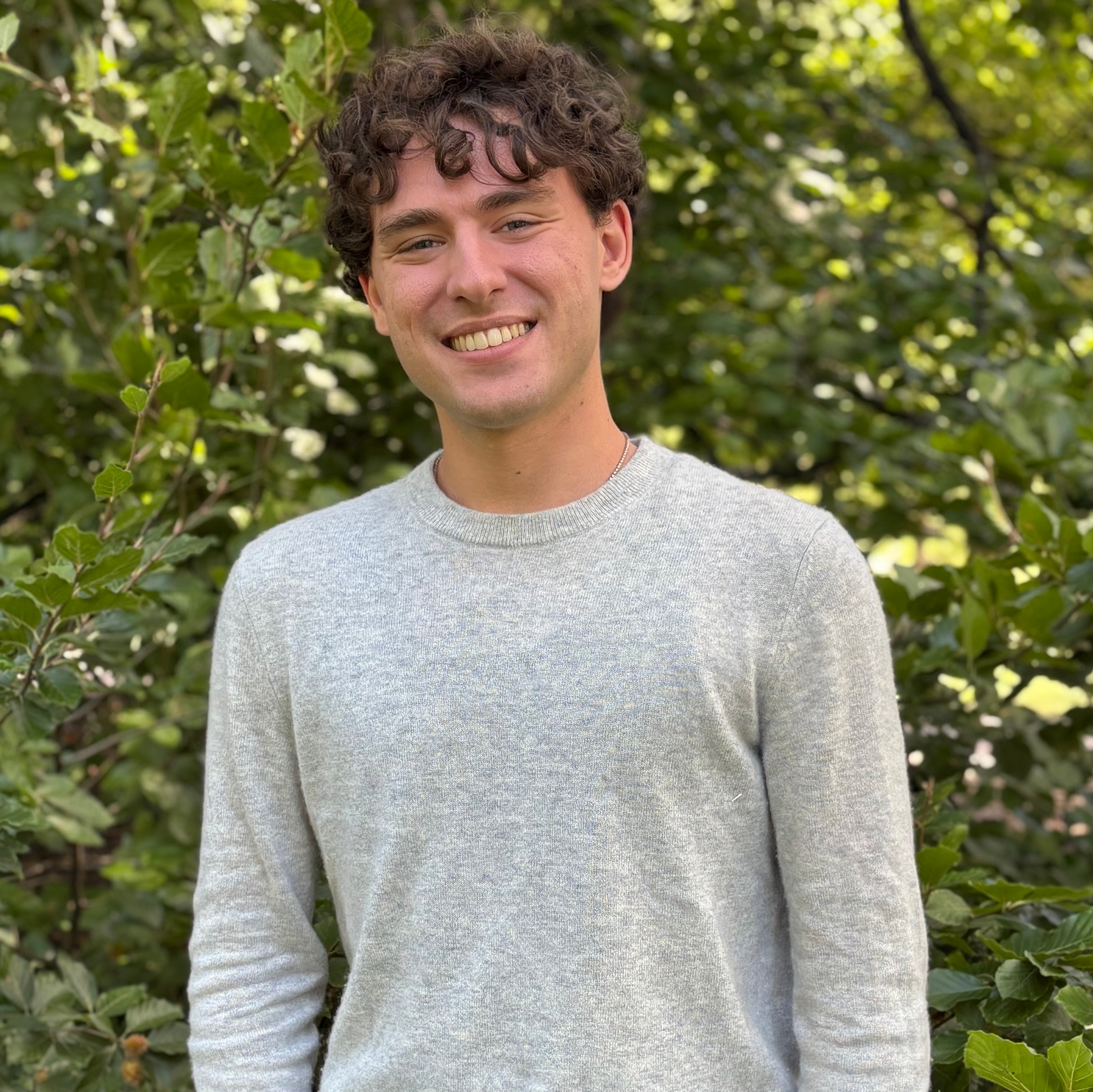 A male Oberlin student in a gray shirt, standing outside.