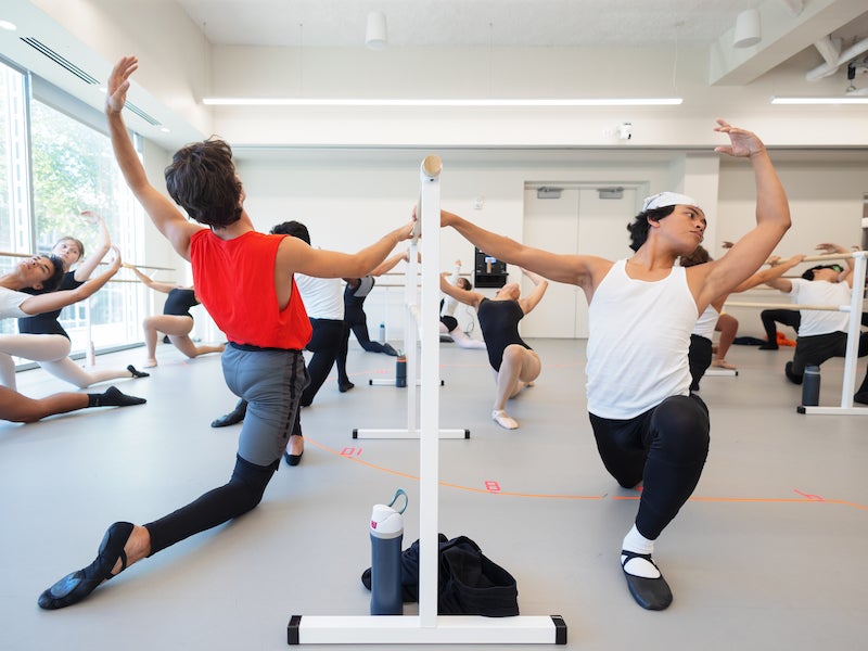 students stretching using ballet barres.