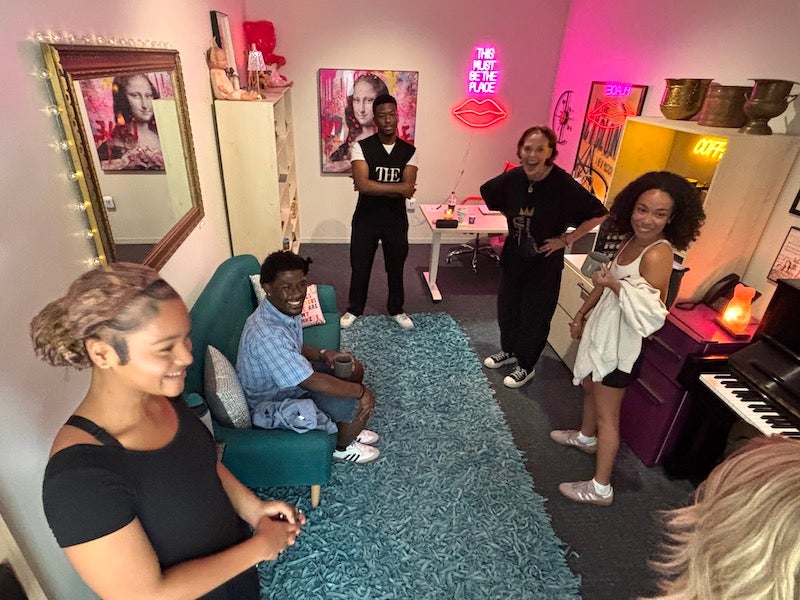 professor and students laughing together in a studio.