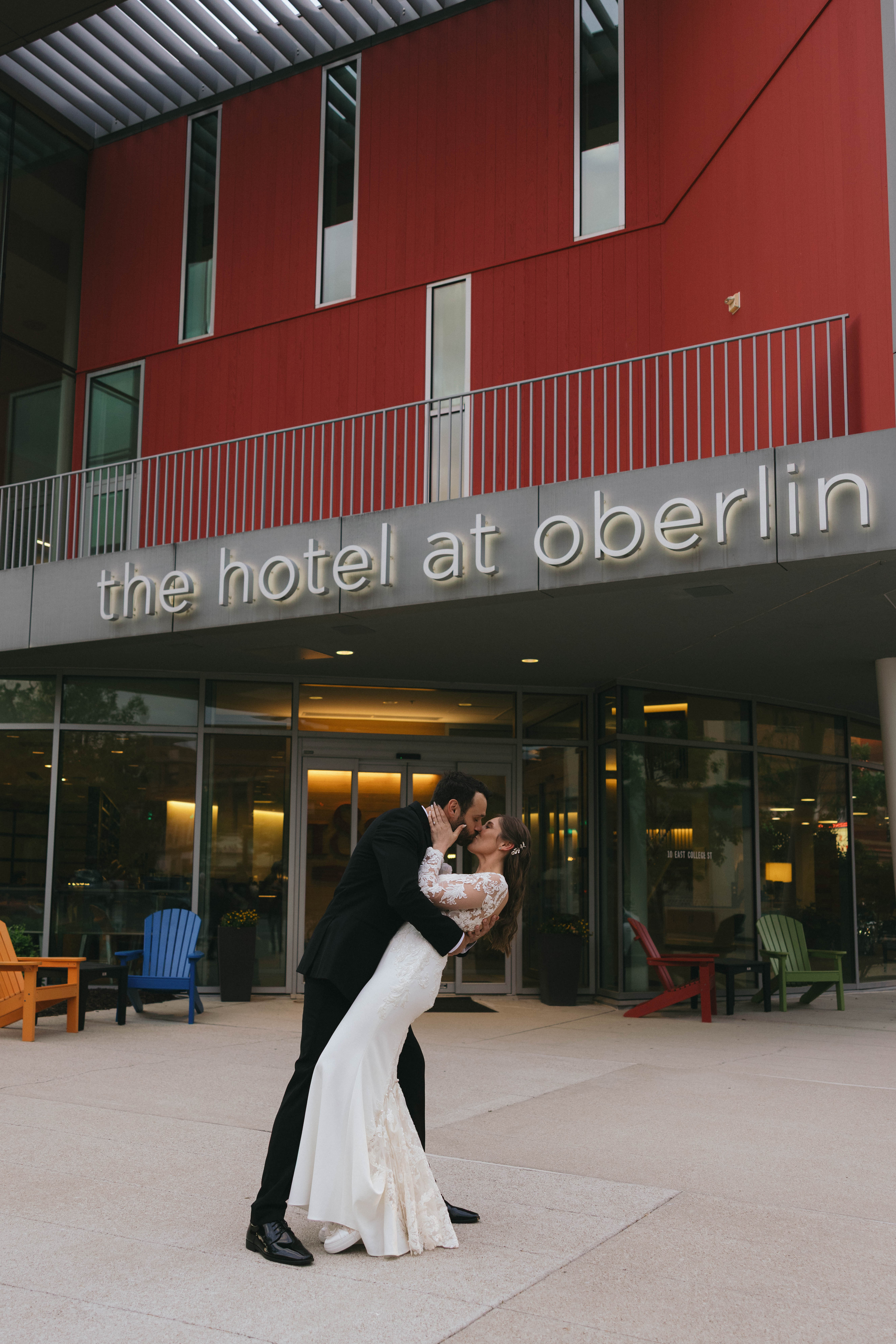 Bride and groom kiss outside of the Hotel at Oberlin