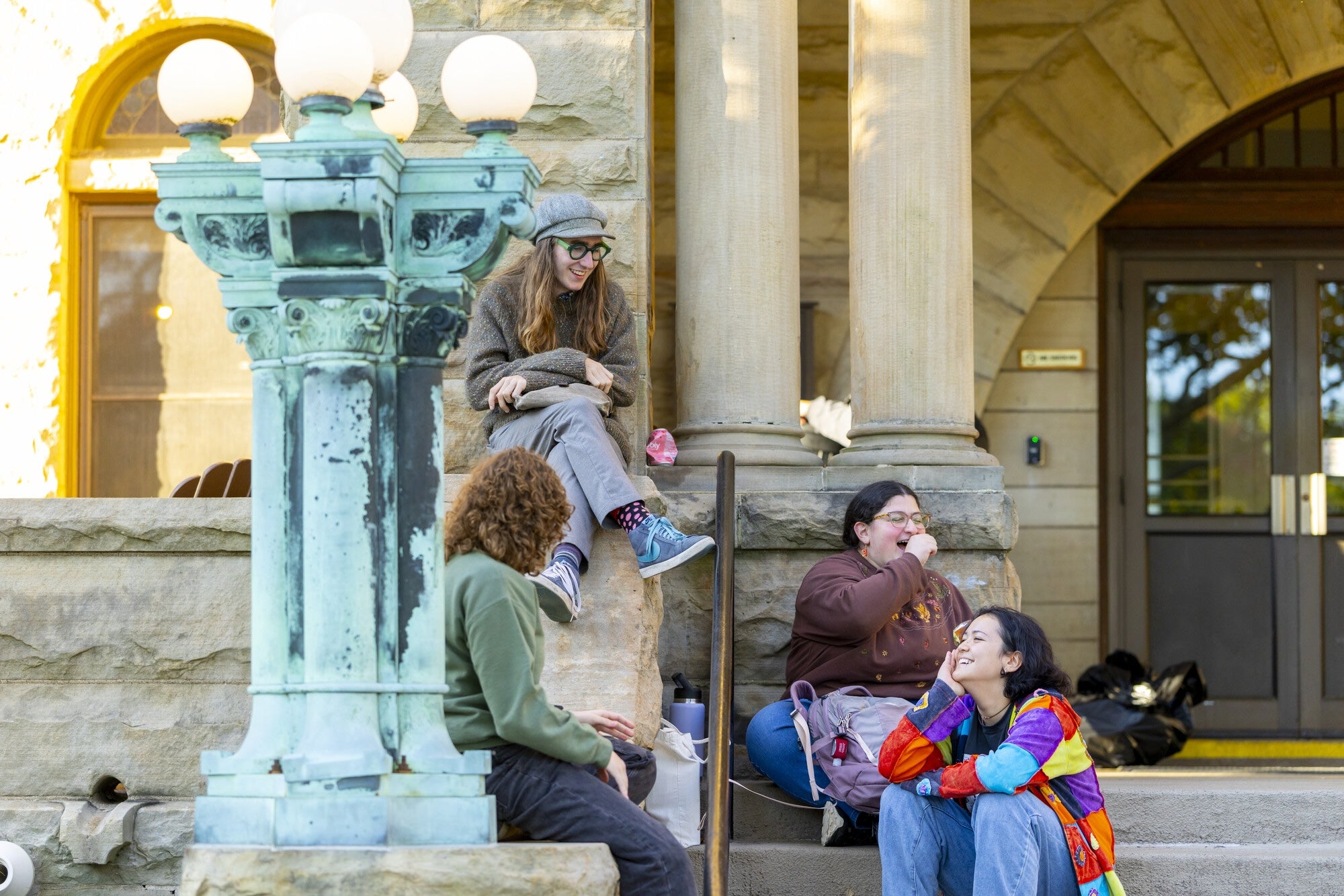 Students sitting near a fountain outside a campus building.