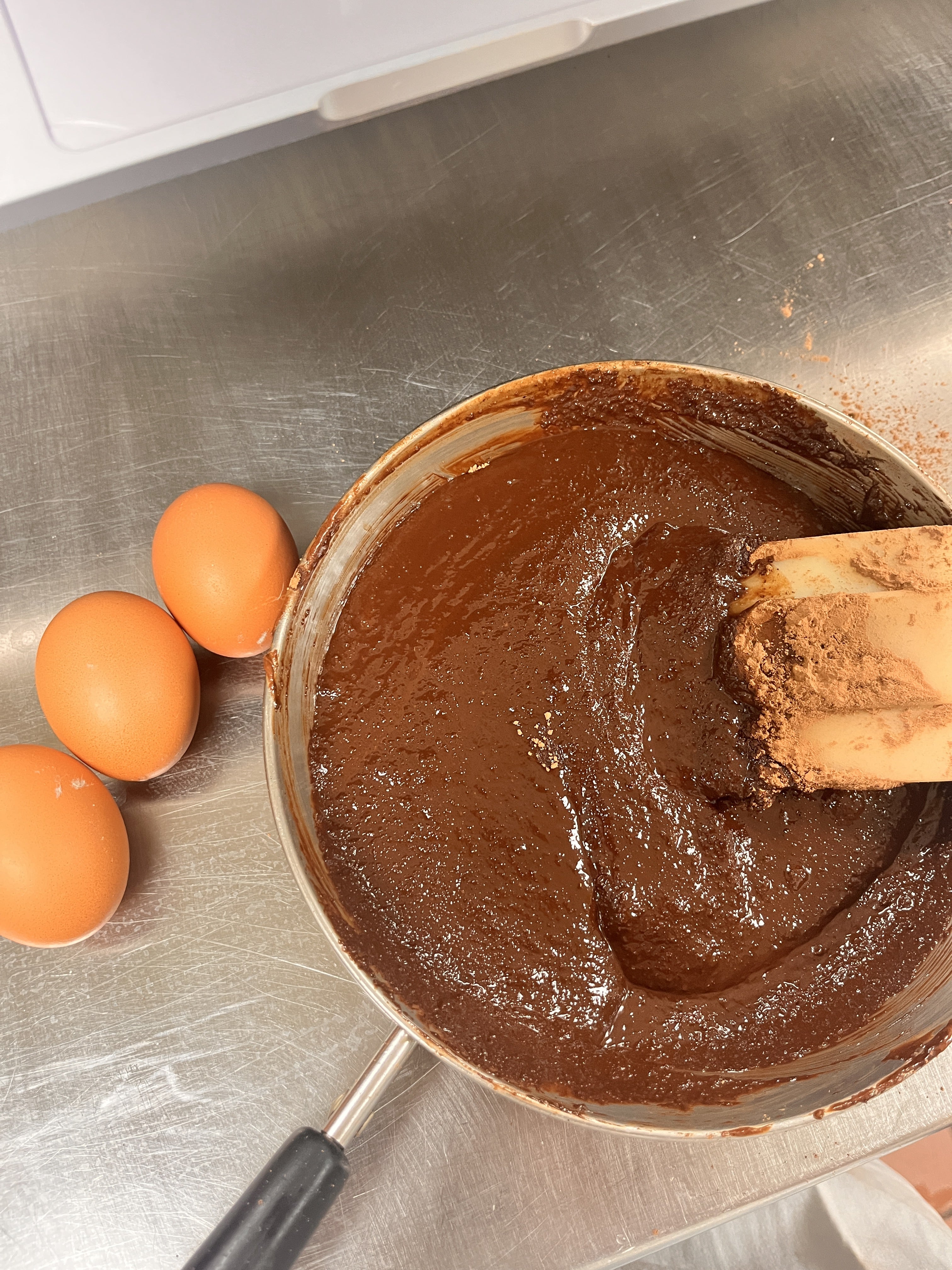 Pan of melted chocolate, a few eggs next to it