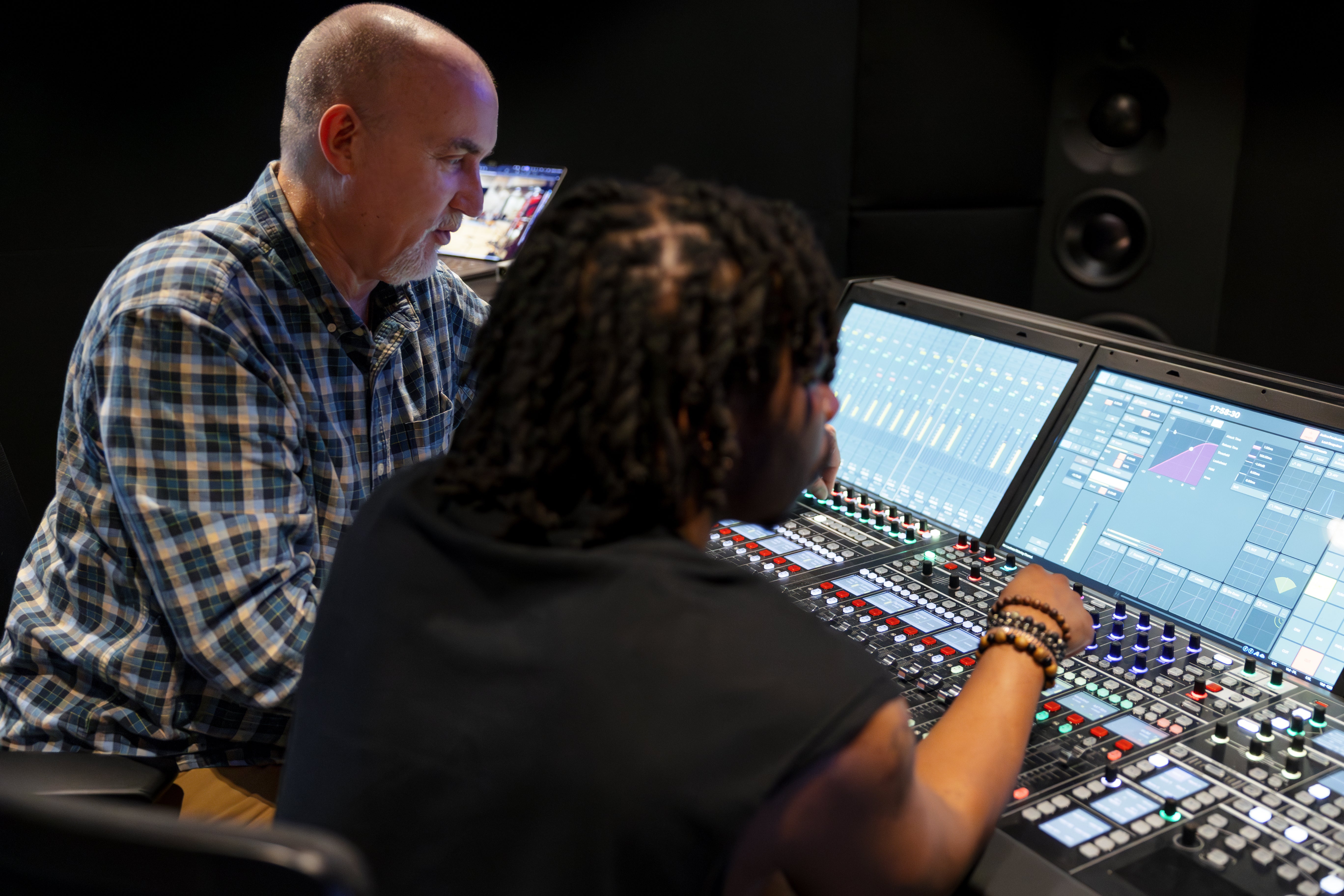 Facutly and student work together in mixing studio space.