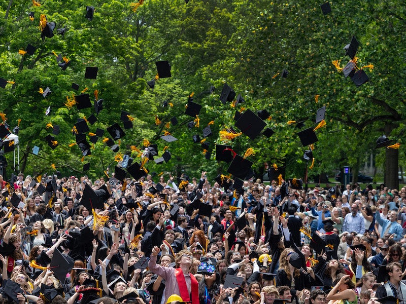 new graduates throwing mortarboards into the air.