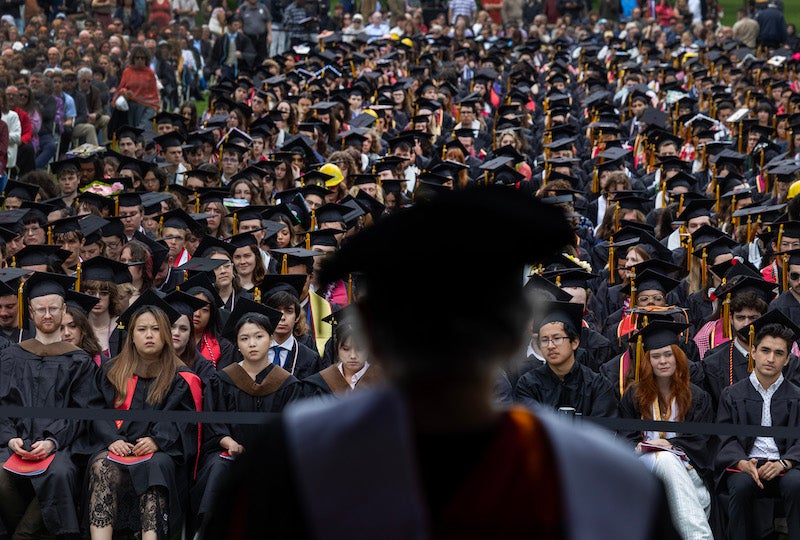view over shoulder of commencement speaker at sea of graduating students.