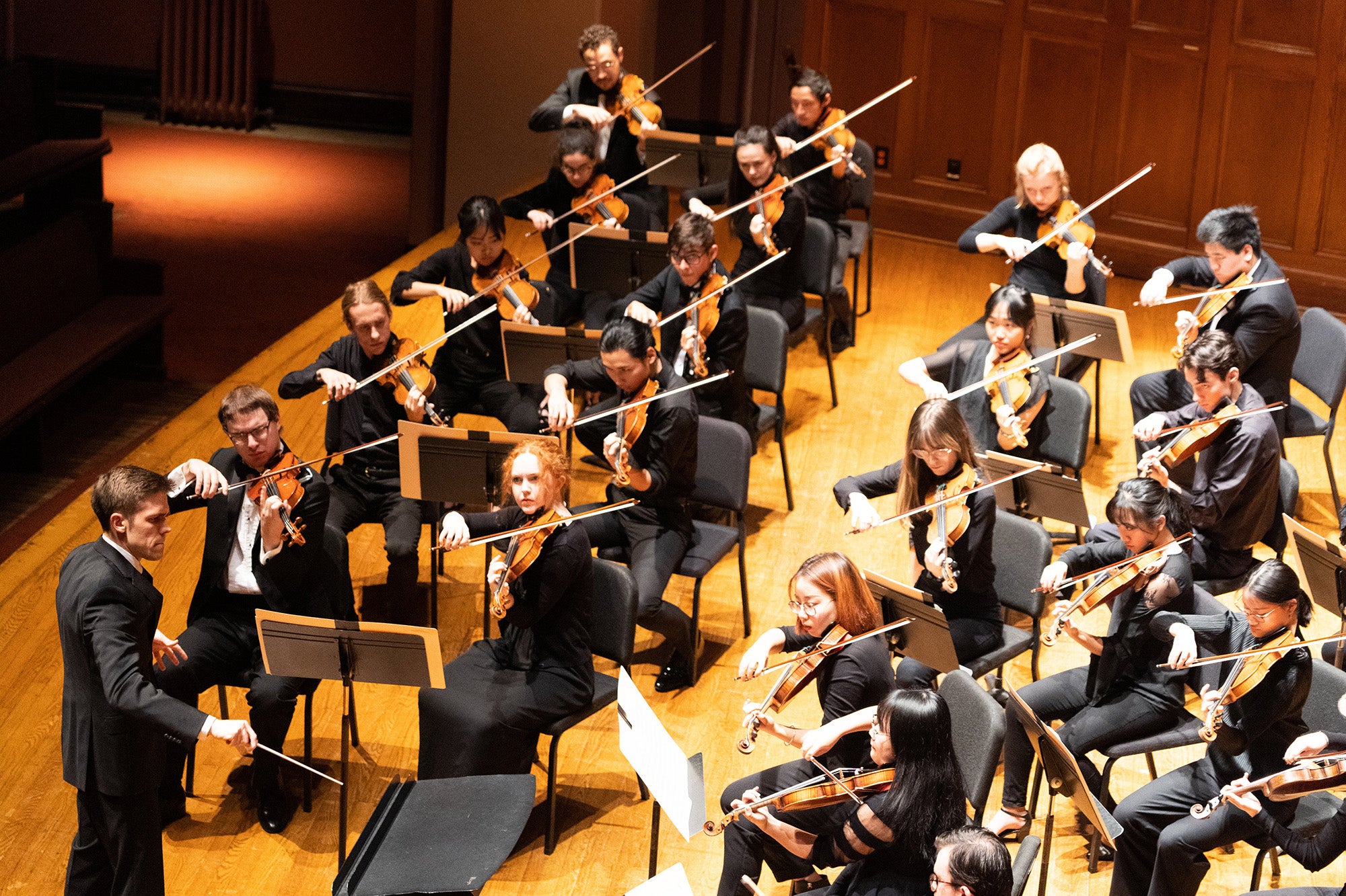 conductor leads an orchestral string section