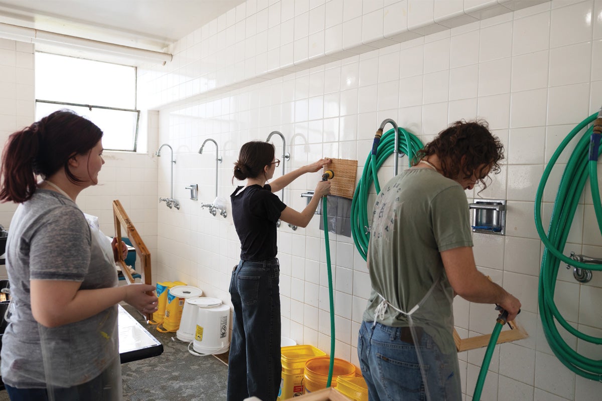 students work in a basement making paper