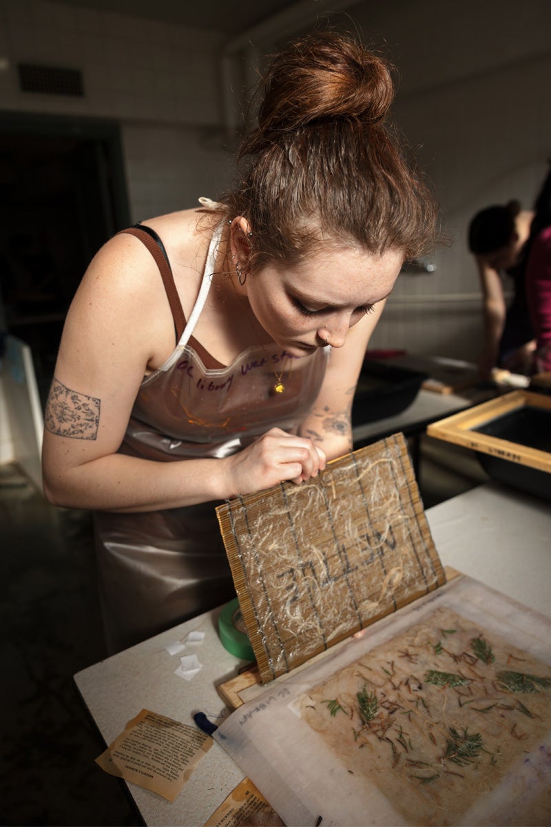 a person peers at paper they have made on a screen