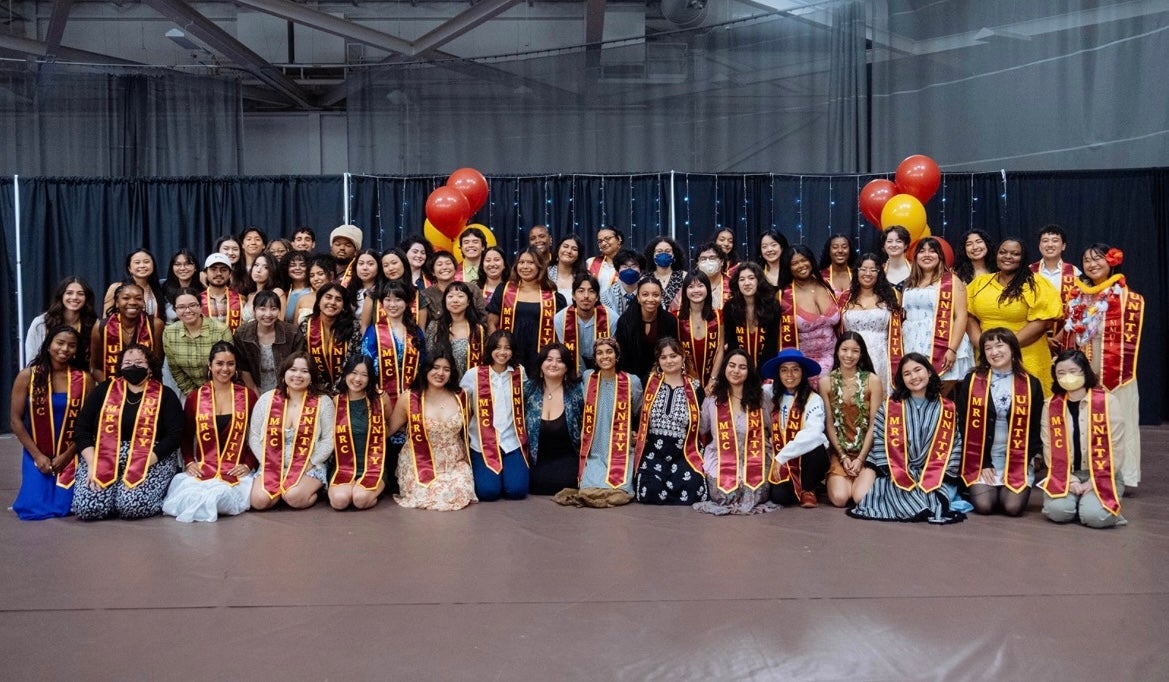 Group of graduating students of various racial and ethnic backgrouds wearing stoles in Oberlin College's colors. MRC and Unity are labeled on the stoles. 