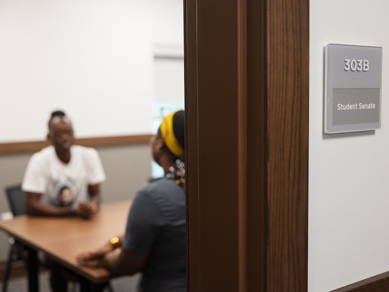 students meeting in a room labeled student senate.