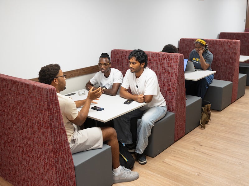 students visiting in high-backed booths.