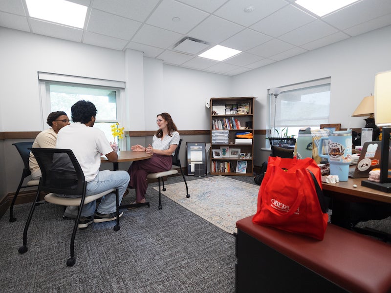 staff and students meet in an office.