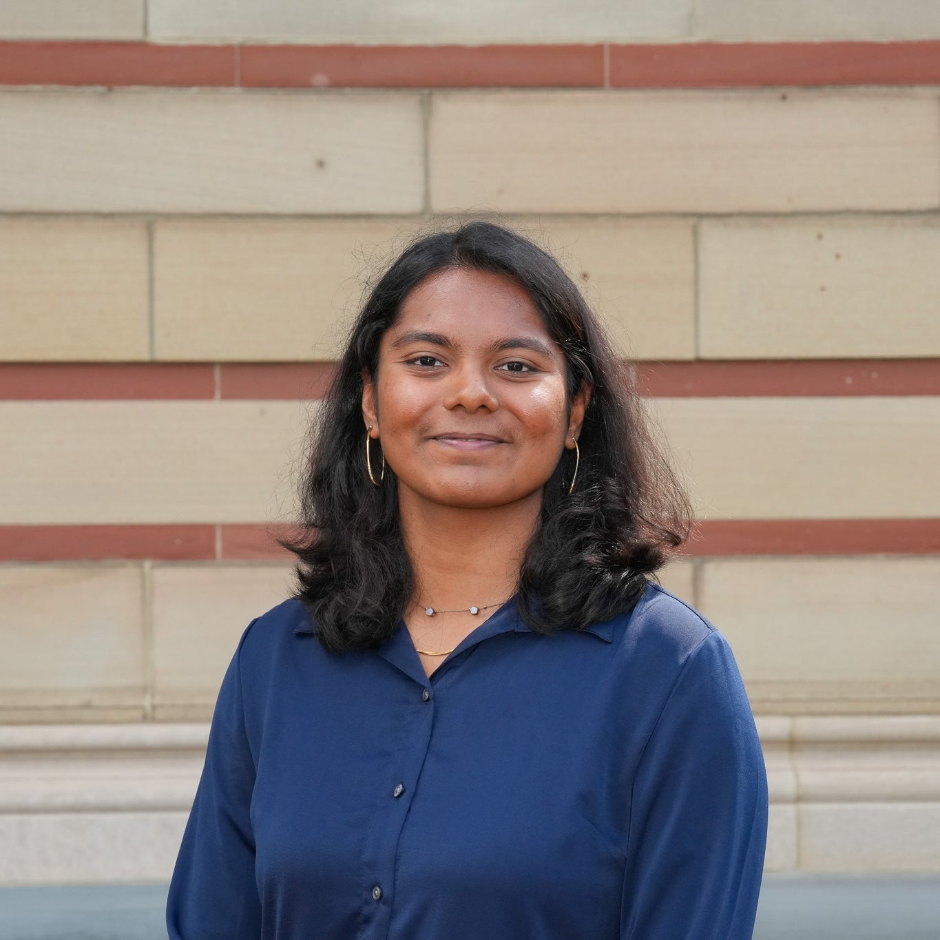 A headshot of a female student in a blue shirt.