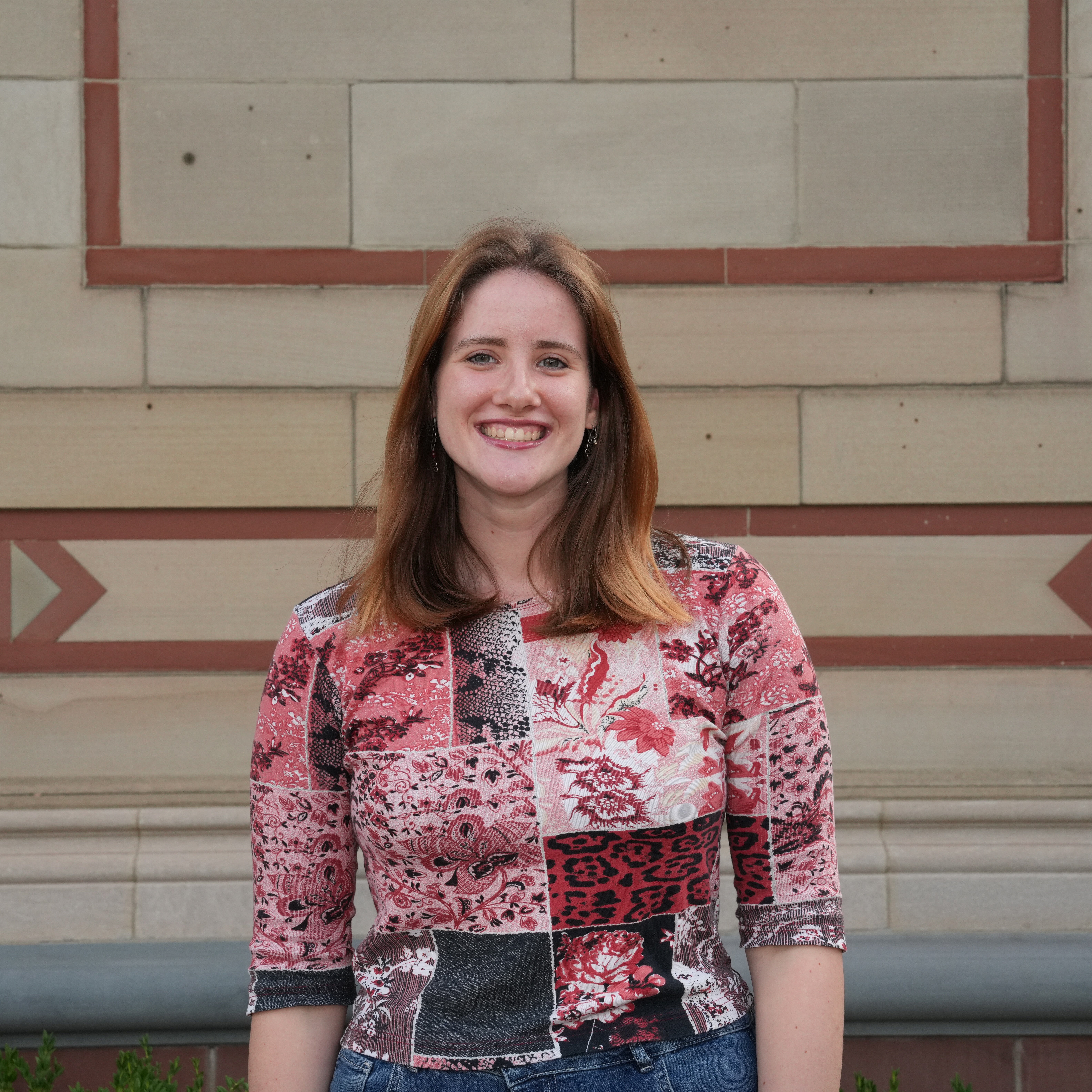 A headshot of a female student in a red shirt.