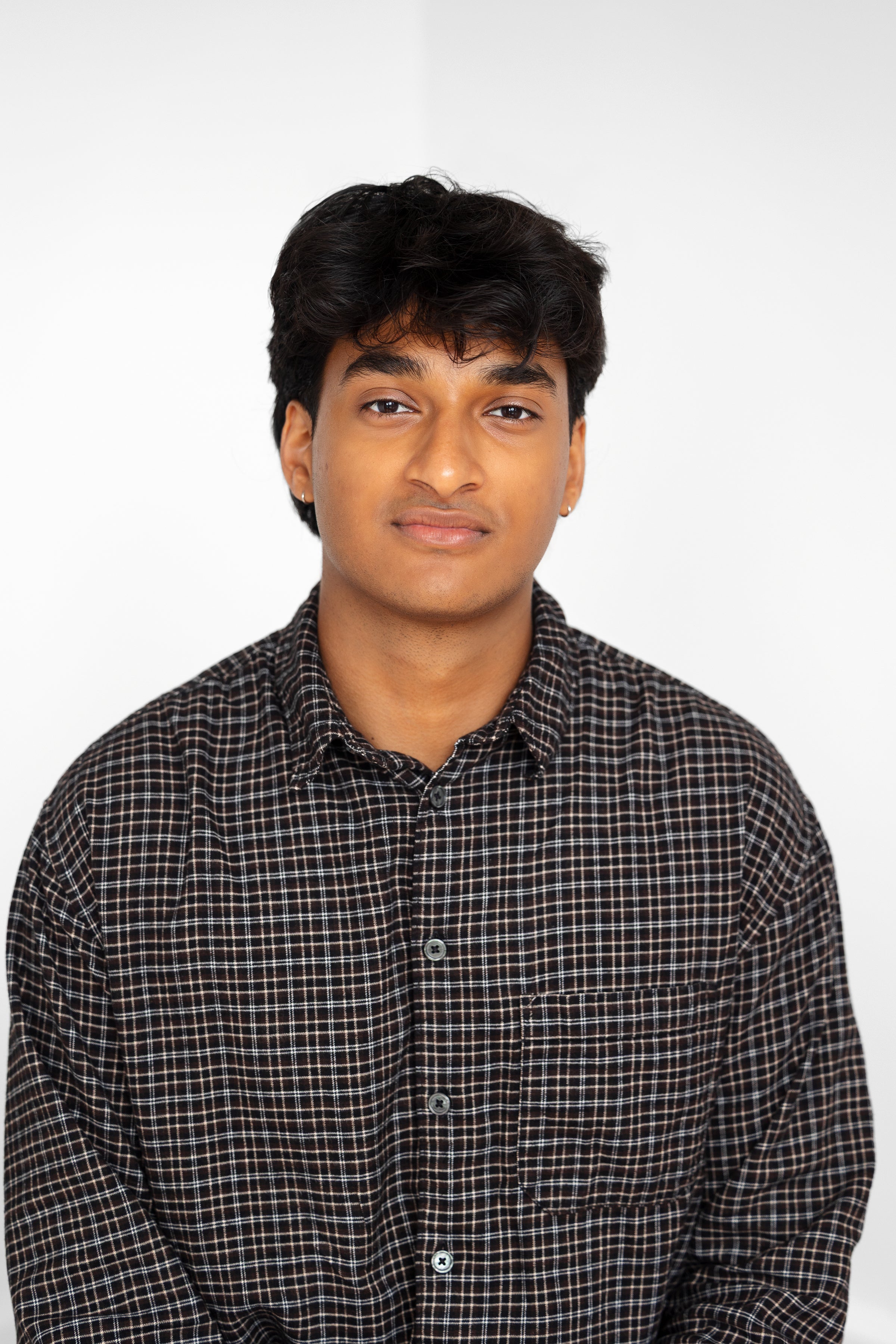 Harsh Satish wearing a black shirt with a grid pattern.