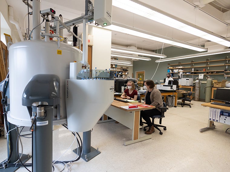 Professor Rachel Saylor and a student acquire data using the department's 400 MHz NMR spectrometer.
