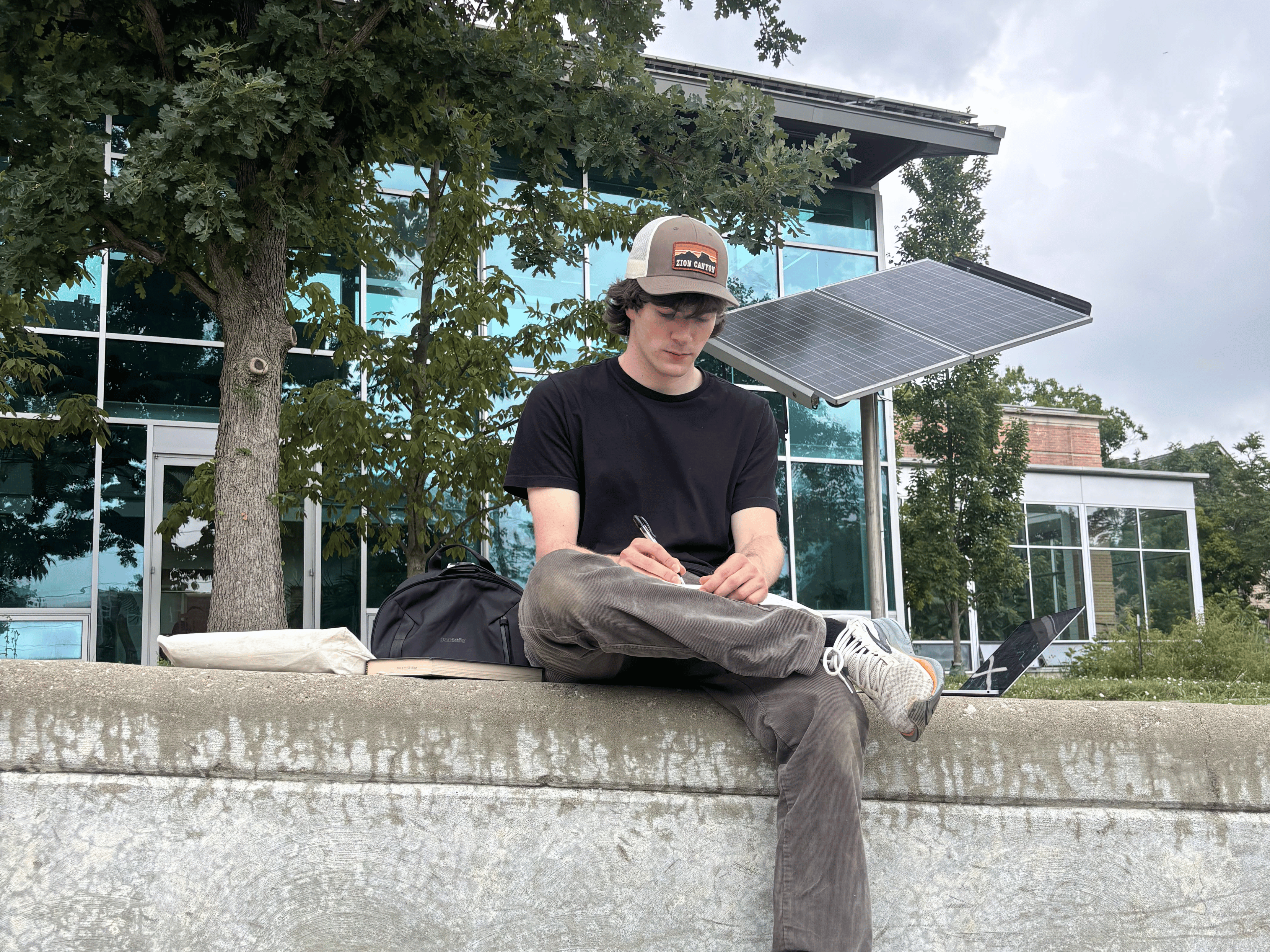 Noah reviewing notes in front of a solar panel.