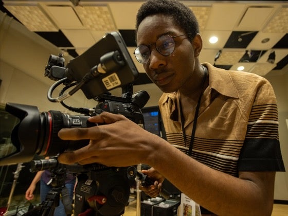 A student operates a professional video camera.