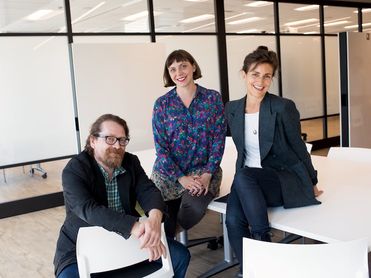 three faculty sitting at desk