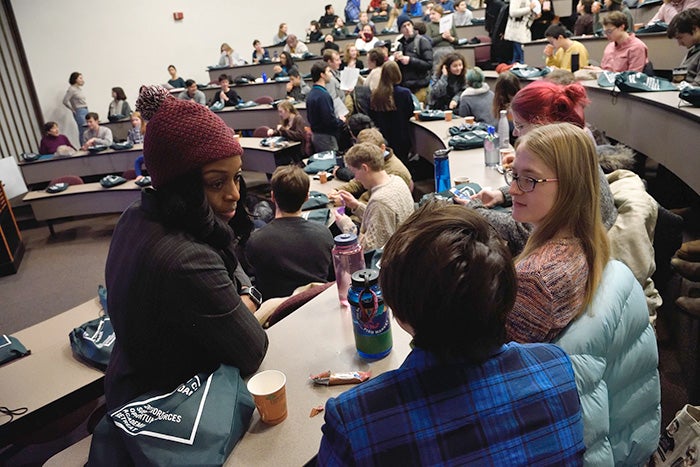 Small groups work together in a lecture hall.