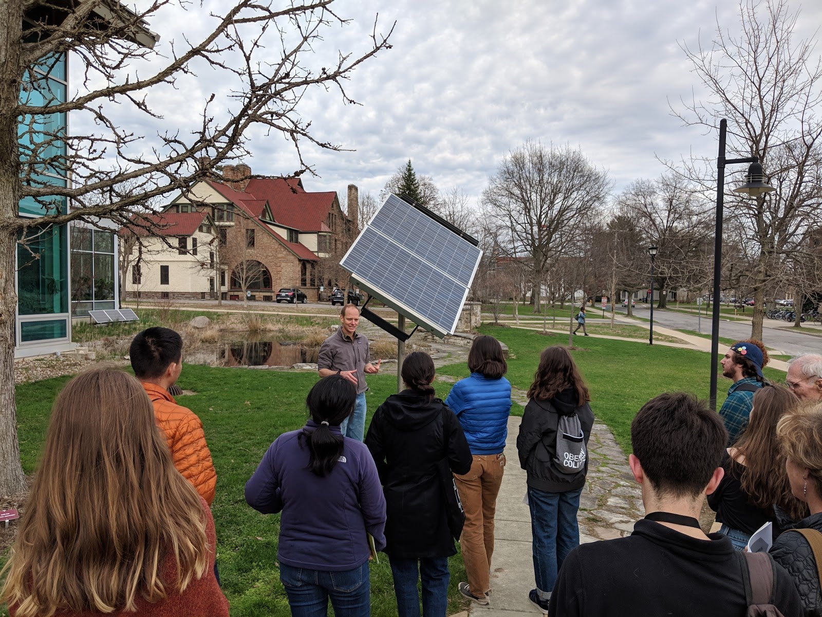 Professor John Petersen speaks to a class in front of the single mounted solar panel.