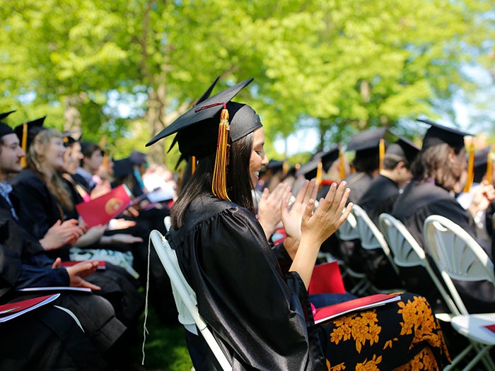 Students seated at graduation on a sunny day.