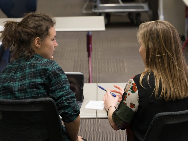 Two people work together at a table.