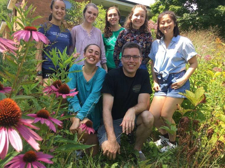 Professor Mike Moore and members of the 2018 Moore Lab smile for an outdoor picture.