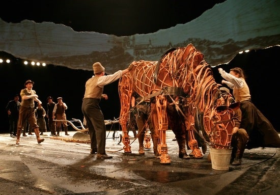 Actors tending to a hand-built horse