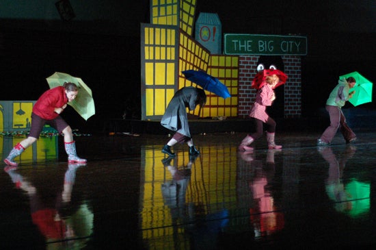 Performers under umbrellas and pretend rain 