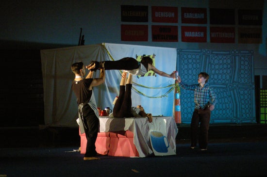 A performer balances on anothers feet in the air