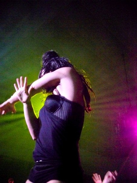 A dancing performer wearing minimal black clothing
