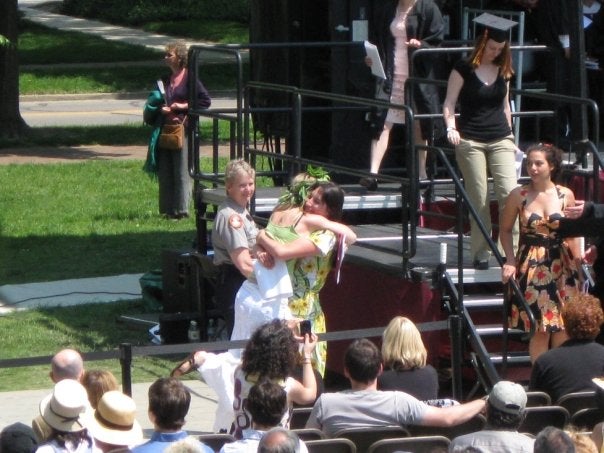 Liz and Aries embrace by the stage.