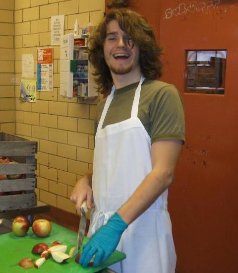 Student posing and slicing apples