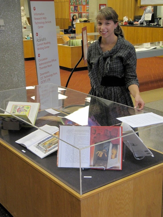 Alice shows a library display case containing several books