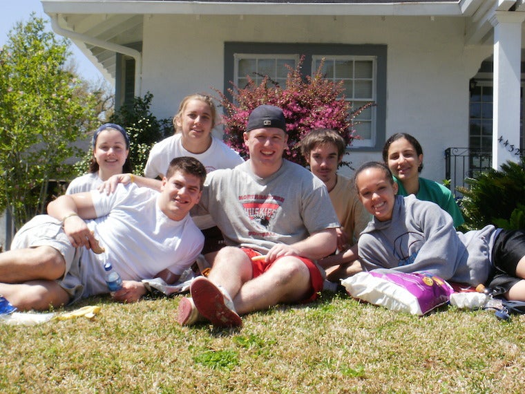 Students posing in the grass of a house