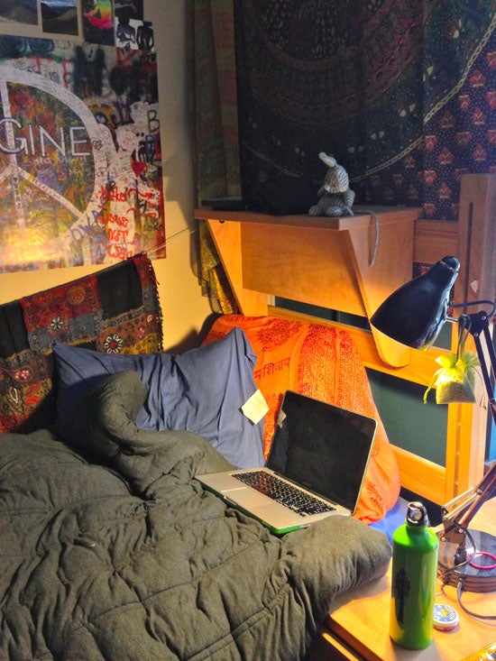 A dorm bed with a laptop 