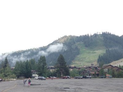 A large parking lot with a green mountain in the backgroun